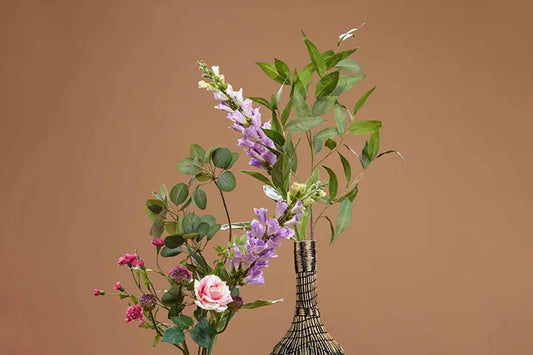 Kunstblumen in Vase auf braunem Hintergrund